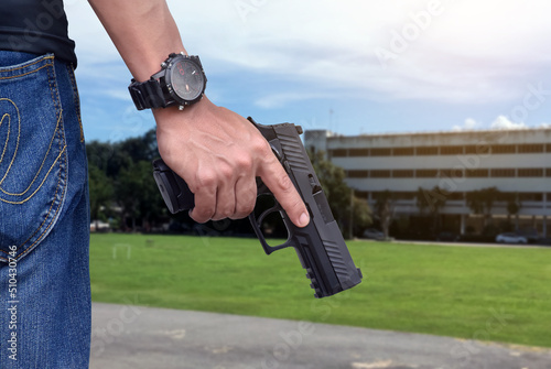 9mm automatic pistol holding in right hand of shooter, concept for security, robbery, bodyguard, gangsters, mafias, and police officers around the world. selective focus on pistol.