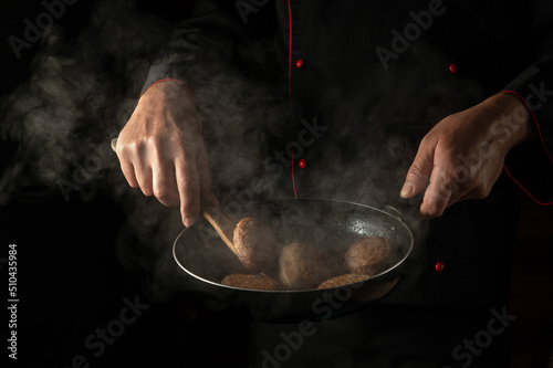 Fototapeta Naklejka Na Ścianę i Meble -  Meat steak on barbecue grill on wooden tool. Cooking cutlets from beef or pork in a pan in the hands of a chef