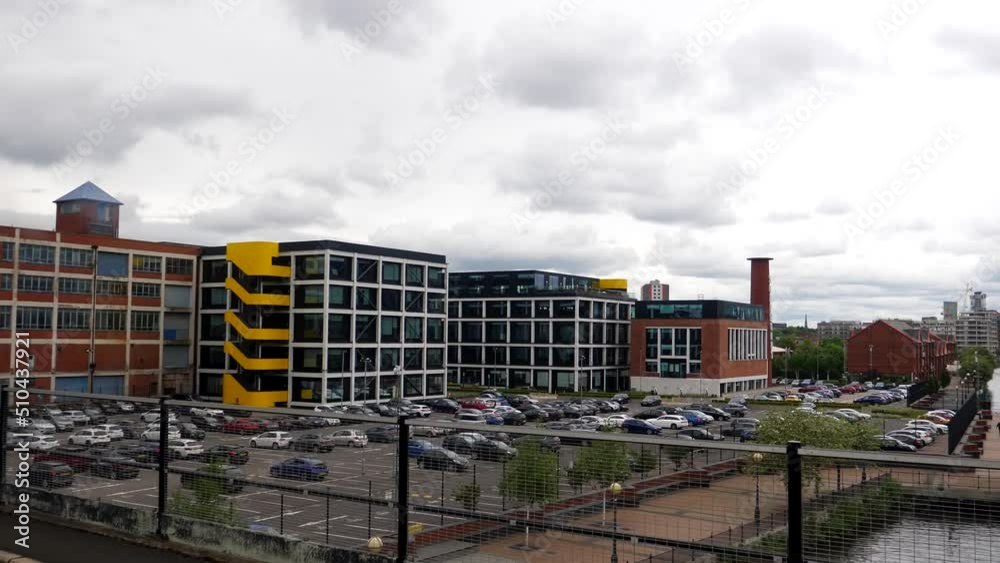 Tram passenger window view of car park for businesses near famous Media city in regenerated Salford area when crossing Manchester Ship Canal. Tram passenger window view of car park for businesses near famous Media city in regenerated Salford area when crossing Manchester Ship Canal.