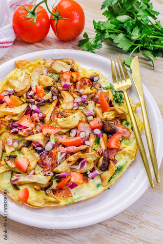 Vegetarian omelette or frittata with herbs, mushrooms, tomatoes and onion