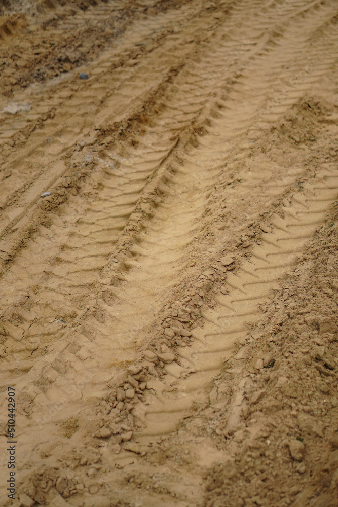 Naklejka premium Tire track on yellow sand. Construction, repair of the street, roads.