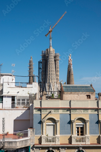 Barcelona, Spain - May 29, 2022: View of the Sagrada Familia cathedral in Barcelona behind the facade of a nice building. photo