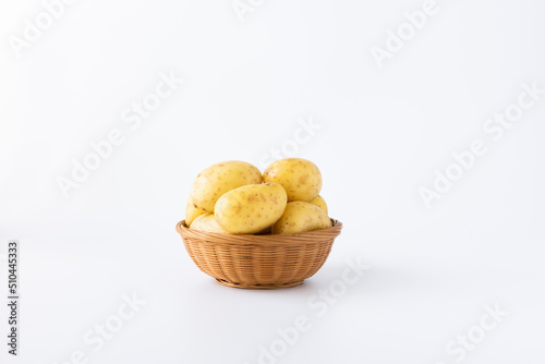 Basket filled with potatoes on white background