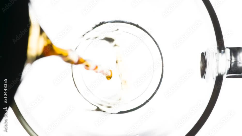 Cup of Fragrant Mint Tea. Glass cup with tea close-up on bright white background. Top view. A stream of hot tea flows from the teapot behind the scene and falls into the cup