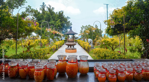 Pray with many candles in the Buddhist temple surrounded by a green park. Orange candles.Green landscapes.