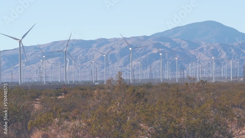 Windmills turbine rotating, wind farm or power plant, alternative green renewable energy generators, industrial field in California, Mojave desert, Tehachapi, USA. Electricity generation on windfarm. photo