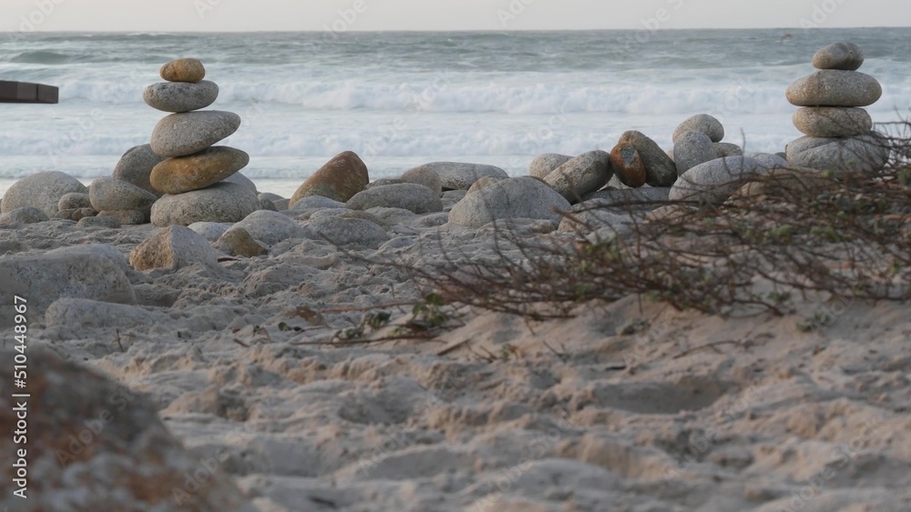 Rock balancing on pebble beach, Monterey 17-mile drive, California coast, USA. Stable pyramid stacks of round stones, sea ocean water waves crashing at sunset. Serenity harmony, calm zen meditation. Rock balancing on pebble beach, Monterey 17-mile drive, California coast, USA. Stable pyramid stacks of round stones, sea ocean water waves crashing at sunset. Serenity harmony, calm zen meditation.