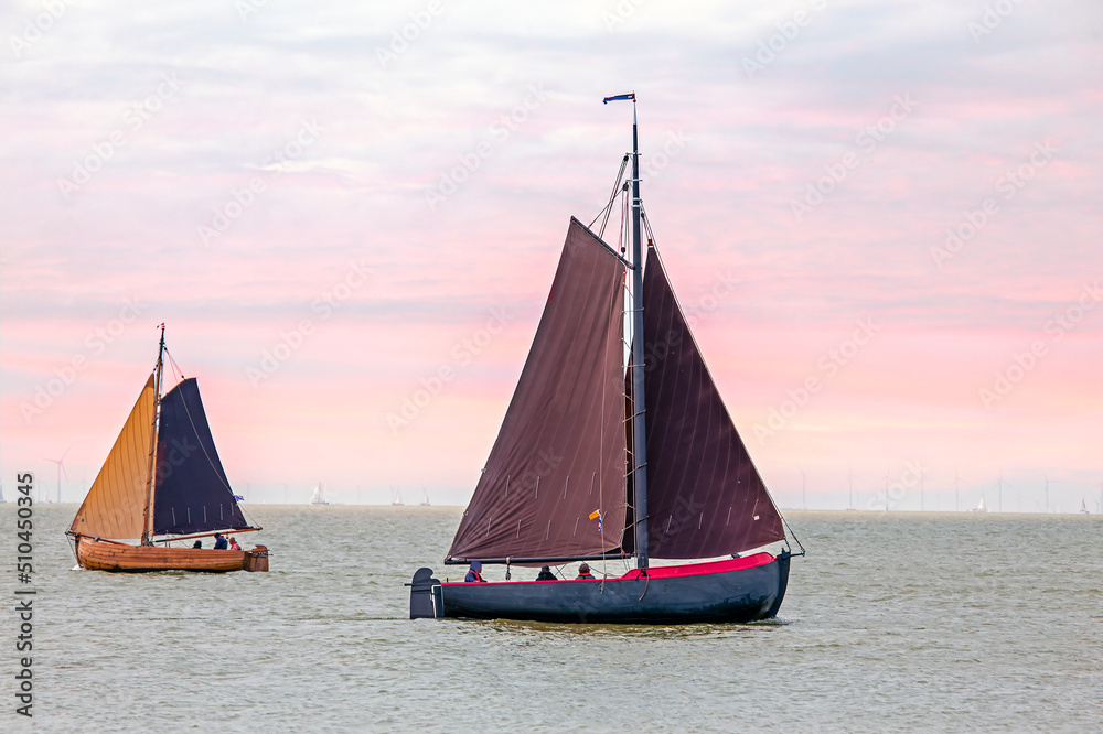 Traditional dutch wooden boats at the IJsselmeer in Friesland the Netherlands at sunset