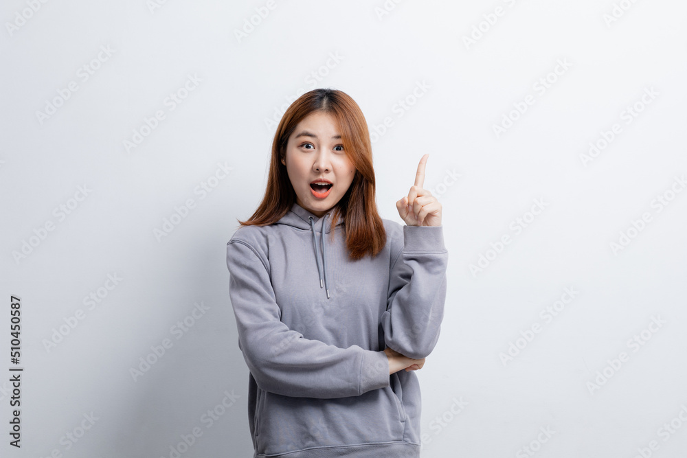 Portrait of Asian woman gesturing pointing at empty space for ad text, portrait concept used for advertisement and signage, isolated over white background, copy space. Portrait of Asian woman gesturing pointing at empty space for ad text, portrait concept used for advertisement and signage, isolated over white background, copy space.