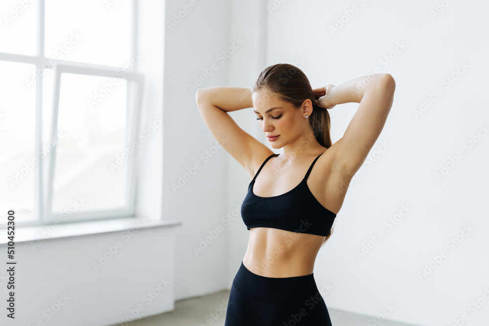 portrait of slim fitness woman making ponytail preparing for sport workout
