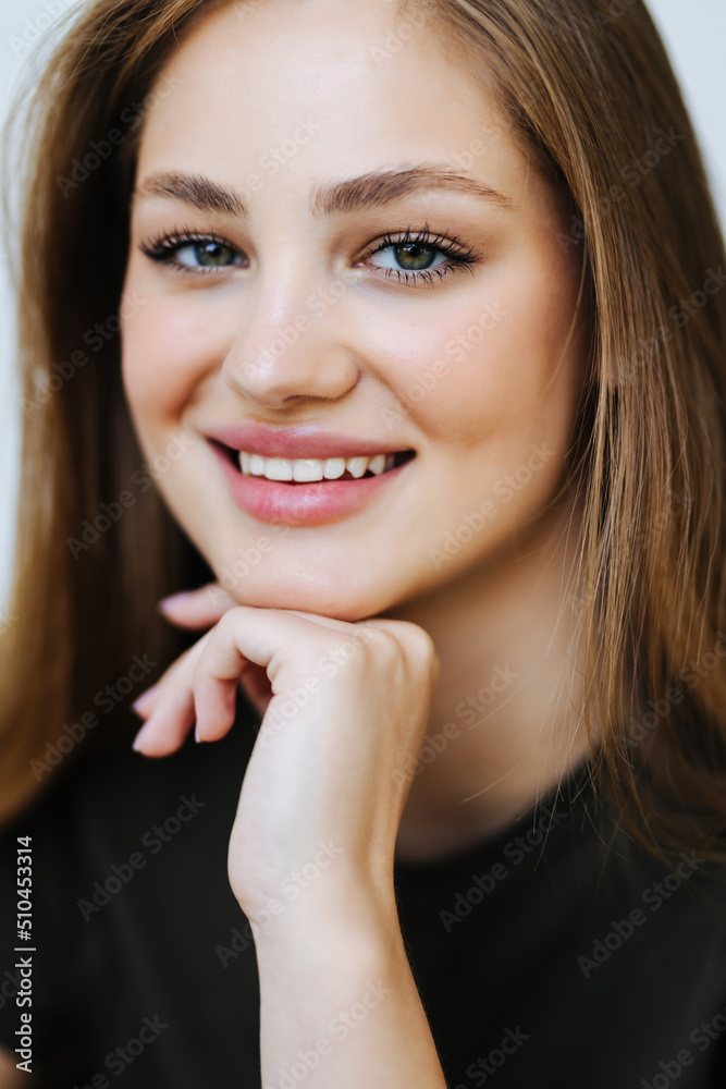 Obraz premium Portrait of a happy teen girl sitting on a couch in the living room at home
