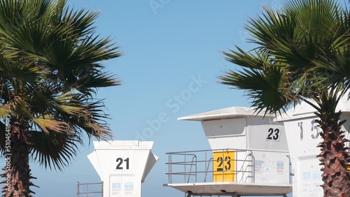 Lifeguard stand and palm tree, life guard tower for surfing on California beach. Summer pacific ocean in USA. Rescue station, coast lifesaver wachtower hut or house by sea. Seamless looped cinemagraph