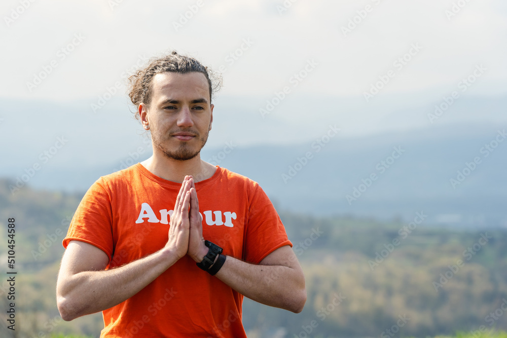 Young man meditating yoga on the rock peak. Relax and calm