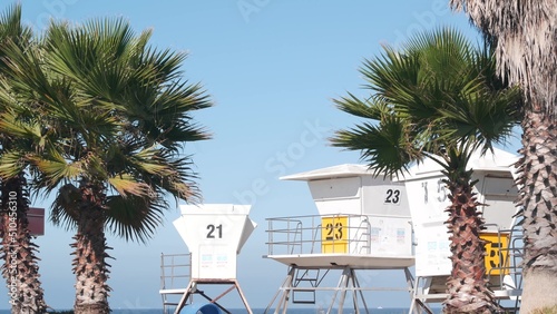 Lifeguard stand and palm tree, life guard tower for surfing on California beach. Summer pacific ocean in USA. Rescue station, coast lifesaver wachtower hut or house by sea. Seamless looped cinemagraph