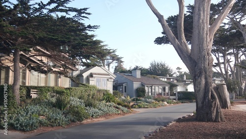 Typical suburban street, residential district, detached houses or single-family homes, road in Carmel city, Monterey, California generic architecture, USA. Neighborhood real estate property in suburb. photo