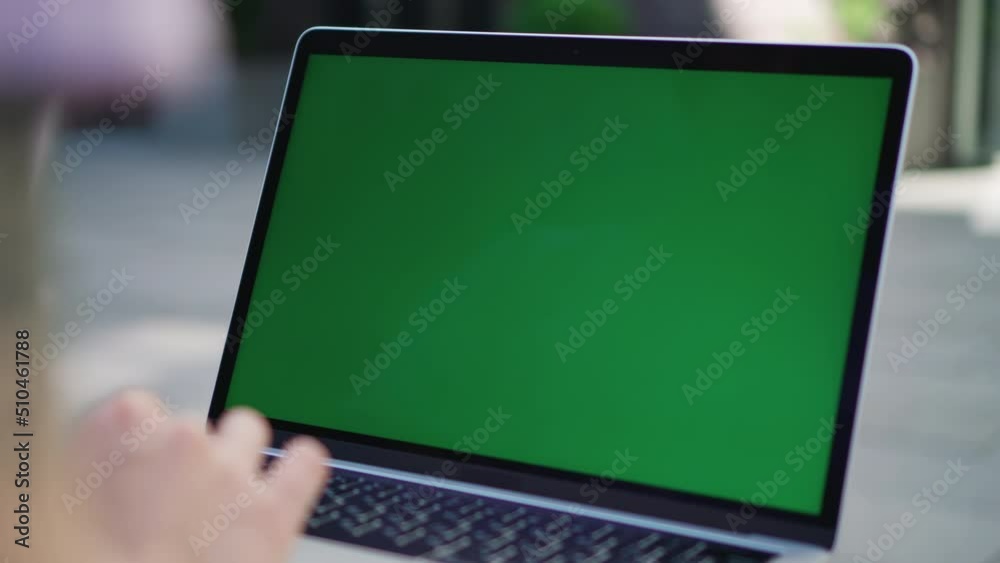 Laptop with Green Screen Close-up. Girl Student or IT Specialist Uses Laptop Sitting on Bench in City Center Laptop with Green Screen Close-up. Girl Student or IT Specialist Uses Laptop Sitting on Bench in City Center