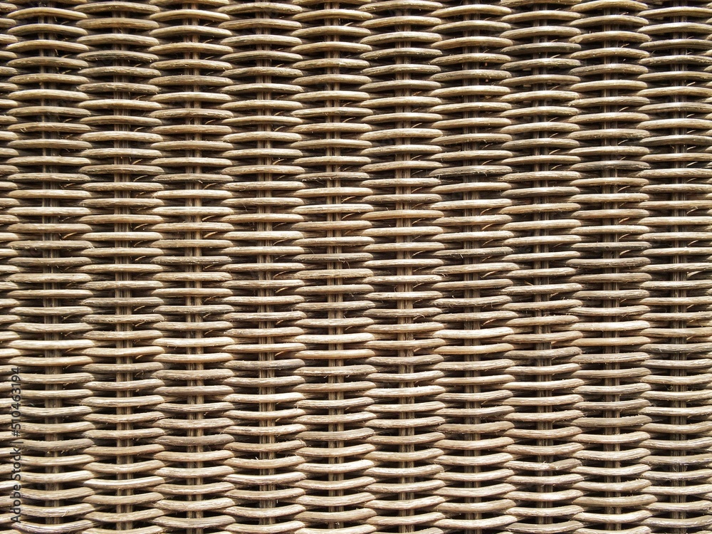 Woven rattan , wooden background. Rattan in close up of a garden chair. Woven rattan , wooden background. Rattan in close up of a garden chair.
