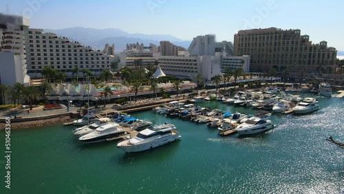 Aerial Panning Shot Of Famous Hotel Buildings In City, Drone Flying Over Sea On Sunny Day - Eilat, Israel photo