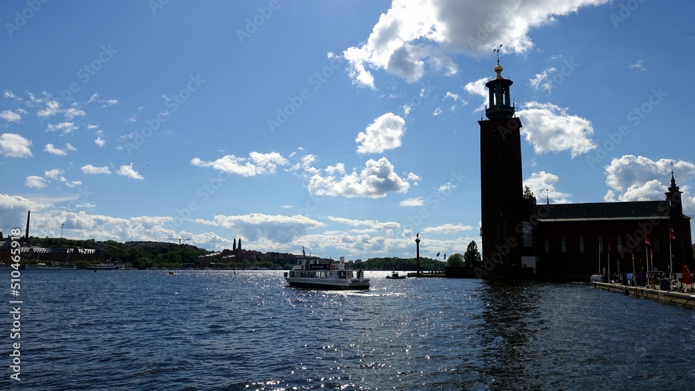 The silhouette of one of Stockholm's historic buildings seen from the sea side with a tourist boat sailing.