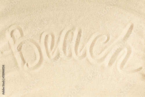 Summer beach writing vacation concept. Word Beach written on sand. Flat lay, top view