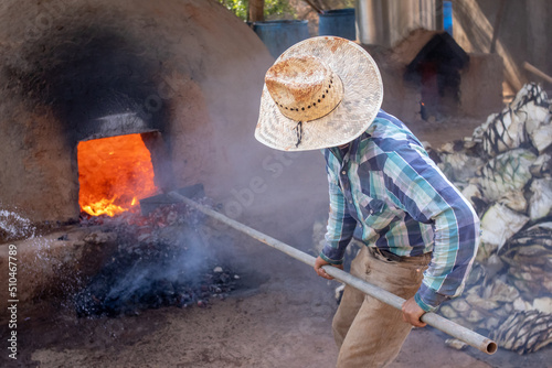 Canvastavla Hombres llenando de piñas de agave el horno de adobe, para preparar raicilla, en
