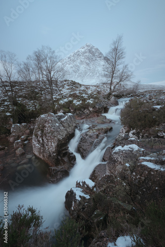 Mountain river and waterfall with stones on the foreground at the foot of Buachaille Etive Mor. Etive Mor Waterfall. At the entrance to the valley of Glencoe in the Scottish Highlands, Scotland