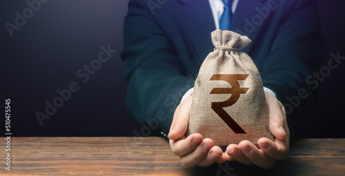 Photos Businessman holds out indian rupee money bag