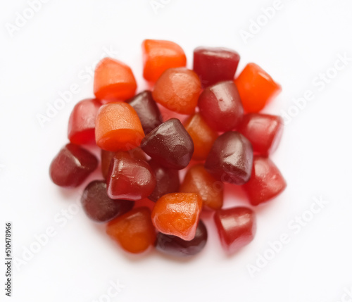 Group of red, orange and purple multivitamin gummies isolated on white background