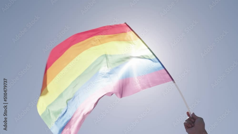 LGBTQ rainbow flag waving in slow motion during the main party in a pride parade with thousands of people LGBTQ rainbow flag waving in slow motion during the main party in a pride parade with thousands of people