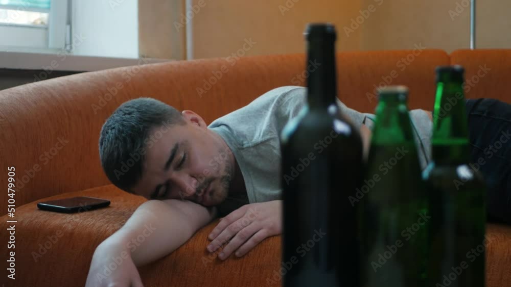 Young alcoholic waking up in the bed after alcohol abuse and drug