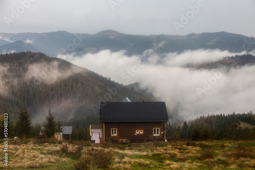 Rural mountain hut in the forest after rain in fog of the Carpathians mountains, Shmotrych, Ukraine
