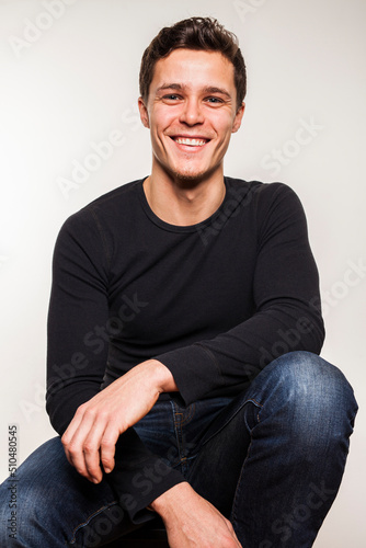 Portrait of young man in black shirt on chair © Atelier Knox