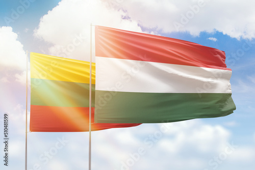 Sunny blue sky and flags of hungary and lithuania