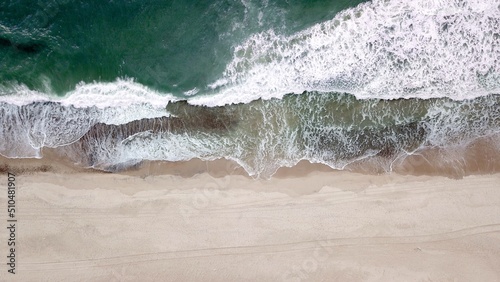large waves of the ocean meet a beach, aerial view, sea level, coast, sea, high quality image photo