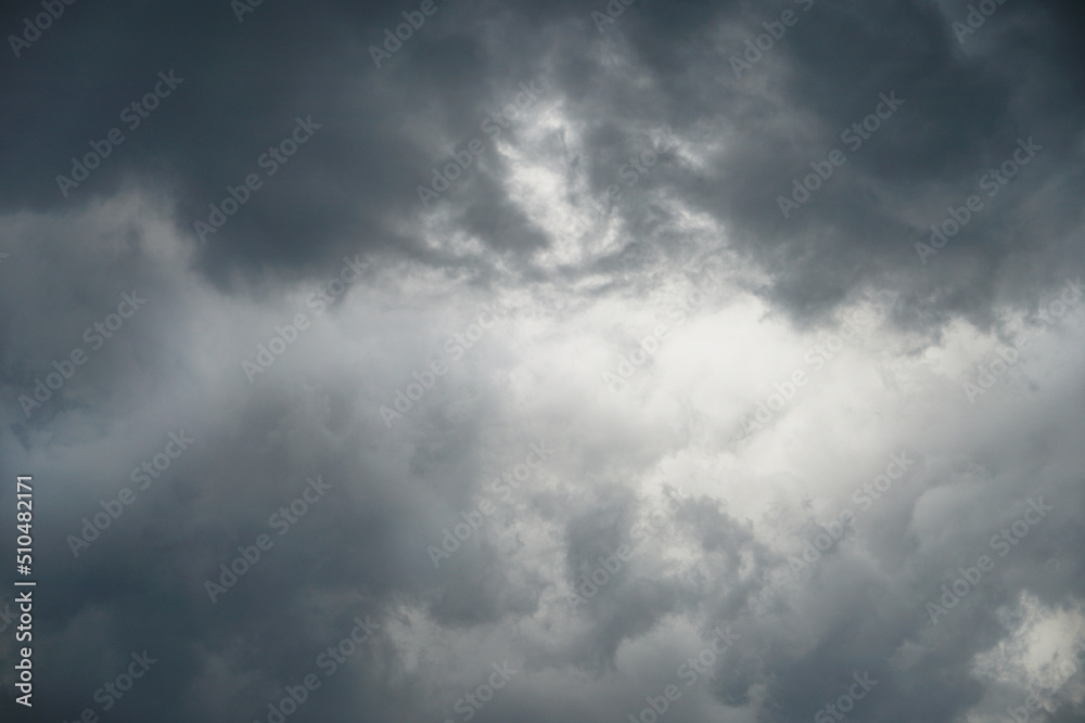 Dark, gloomy, stormy, rainy sky with rays of light. Terrible hurricane clouds. Background image for design