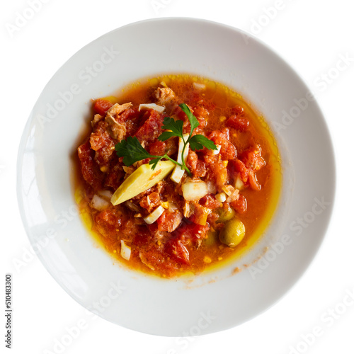 Mojete con queso, simple dish made from tomatoes, canned tuna, eggs, olives, onion, garlic and virgin olive oil, garnished with cheese, cuisine of La Mancha, Spain. Isolated on white background