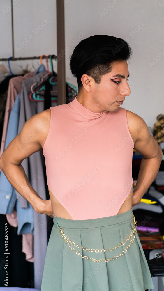 Gay latino person wearing women's clothes, and looking at himself in the mirror. Lifestyle.	