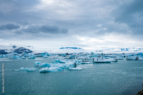 Beautiful icebergs floating in glacial lake. Scenic view of glacial ice formations against cloudy sky. Idyllic scenery of Jokulsarlon glacier lagoon during polar climate.