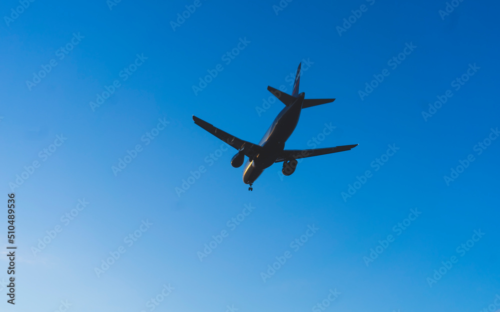 The silhouette of a passenger plane coming in for landing against the backdrop of the sunset sky. The silhouette of a passenger plane coming in for landing against the backdrop of the sunset sky.