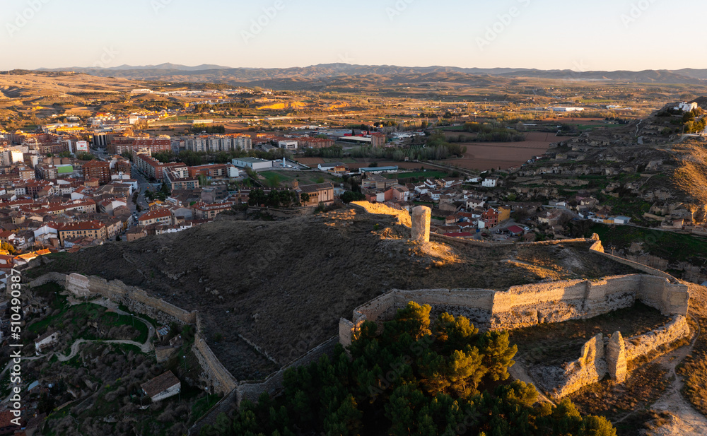 Scenic drone view of ancient ruined Mocha tower or Consolation Castle on hilltop surrounded by remains of fortified walls on background of Calatayud townscape in spring, Spain