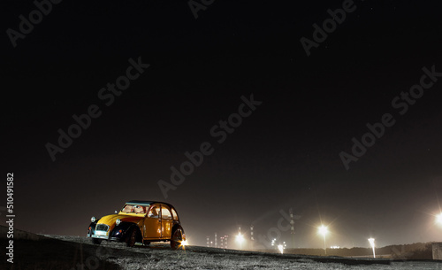 Foto Carro amarelo clássico em fundo noturno