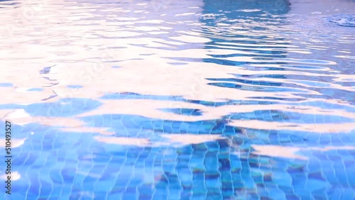 Água de piscina com pequenas ondas. Água em movimento em uma piscina de vinil com mosaico cheio de quadrados em diferentes tons de cor azul. photo