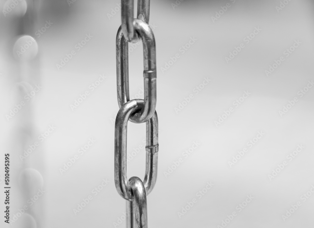 Diagonal, partial blurred iron chain on blurred background. Low angle view of steel chains. Diagonal, partial blurred iron chain on blurred background. Low angle view of steel chains.