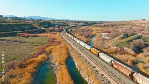 AERIAL - Train on railroad tracks close to Bluffdale, Utah, forward lowering shot photo