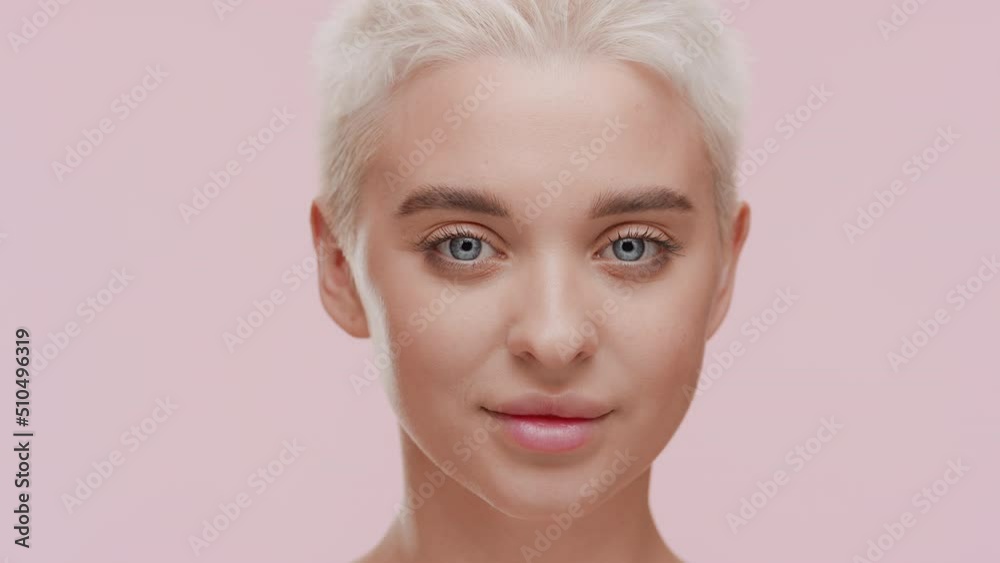 Big close-up shot of pretty young slim blond Caucasian woman makes hand camera gesture on pale pink background | Acne removal concept Big close-up shot of pretty young slim blond Caucasian woman makes hand camera gesture on pale pink background | Acne removal concept