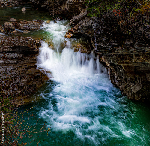 A small cascade with smooth white flowing water on Johnston Creek in Johnston Creek Canyon in Banff National Park Canada