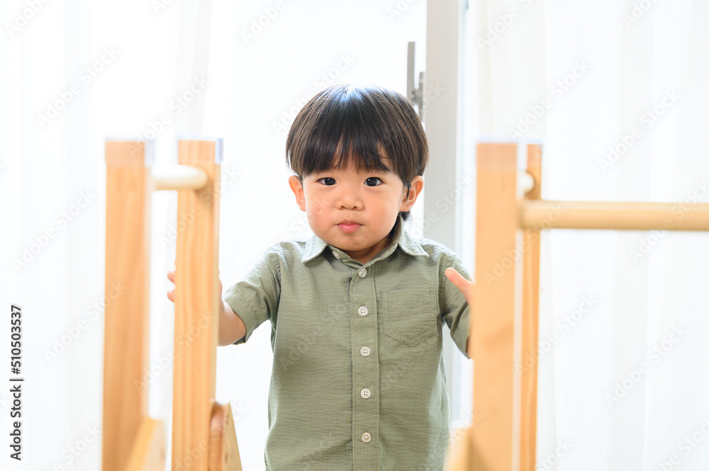 子供部屋の滑り台で遊ぶ幼児　カメラ目線