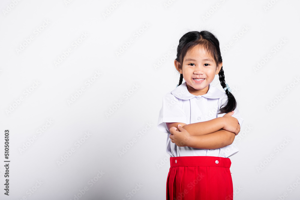 Asian toddler smile happy wearing student thai uniform red skirt stand with arms folded in studio shot isolated on white background, Portrait little children girl preschool crossed arm, Back to school Asian toddler smile happy wearing student thai uniform red skirt stand with arms folded in studio shot isolated on white background, Portrait little children girl preschool crossed arm, Back to school