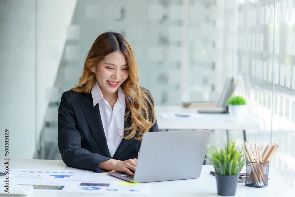 Portrait of young Asian business woman using laptop computer in the office. Portrait of young Asian business woman using laptop computer in the office.
