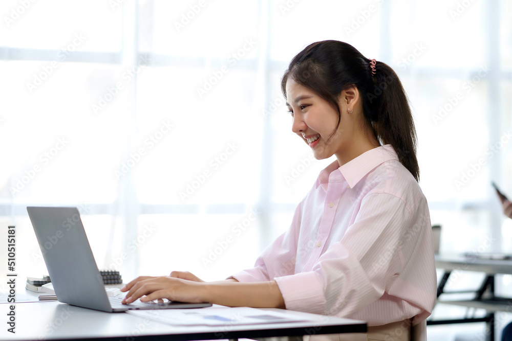 Portrait of young Asian business woman using laptop computer in the office. Portrait of young Asian business woman using laptop computer in the office.